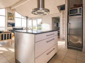 A modern kitchen with a central island, stainless steel appliances, and a view of the outdoors. - 5 Star Holiday Home in Hjorring (Hjørring)