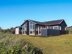 A modern house with large windows and a sloped roof. - 5 Star Holiday Home in Hjorring (Hjørring)