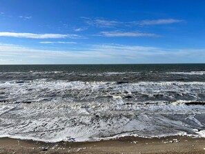 A beach with waves crashing onto the shore under a clear sky. - 5 Star Holiday Home in Hjorring (Hjørring)
