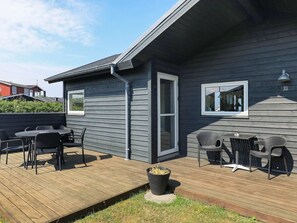 Ein modernes Haus mit Terrasse, Tür und Fenster.