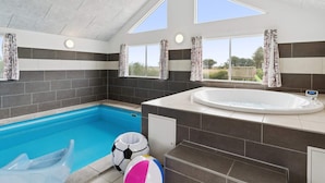 Ein modernes Badezimmer mit integriertem Pool, einer großen Badewanne und einer Duschkabine.