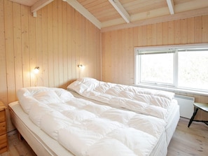 A room with two beds, wooden walls, a window, and a desk. - 4 Star Holiday Home in Lokken (Lokken)