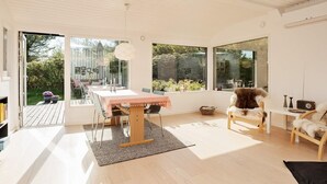 Un interior moderno con una mesa de comedor, sillas y un ventanal grande.