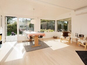 A modern interior with a dining table, chairs, and a large window. - 4 Star Holiday Home in Vejby (Vejby)