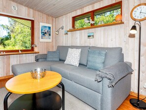 A cozy room with a grey sofa, a small round table, and a lamp. - 4 Star Holiday Home in Lokken (Lokken)