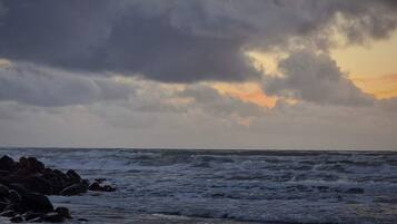 A beach with waves and rocks.