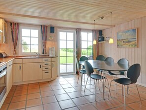 A kitchen with a dining area, wooden ceiling, and a painting on the wall. - Tasteful Holiday Home in Hemmet near Sea (Hemmet)