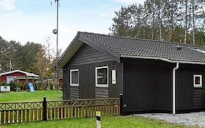 A single-story building with a dark exterior, a sloped roof, and a small porch area.