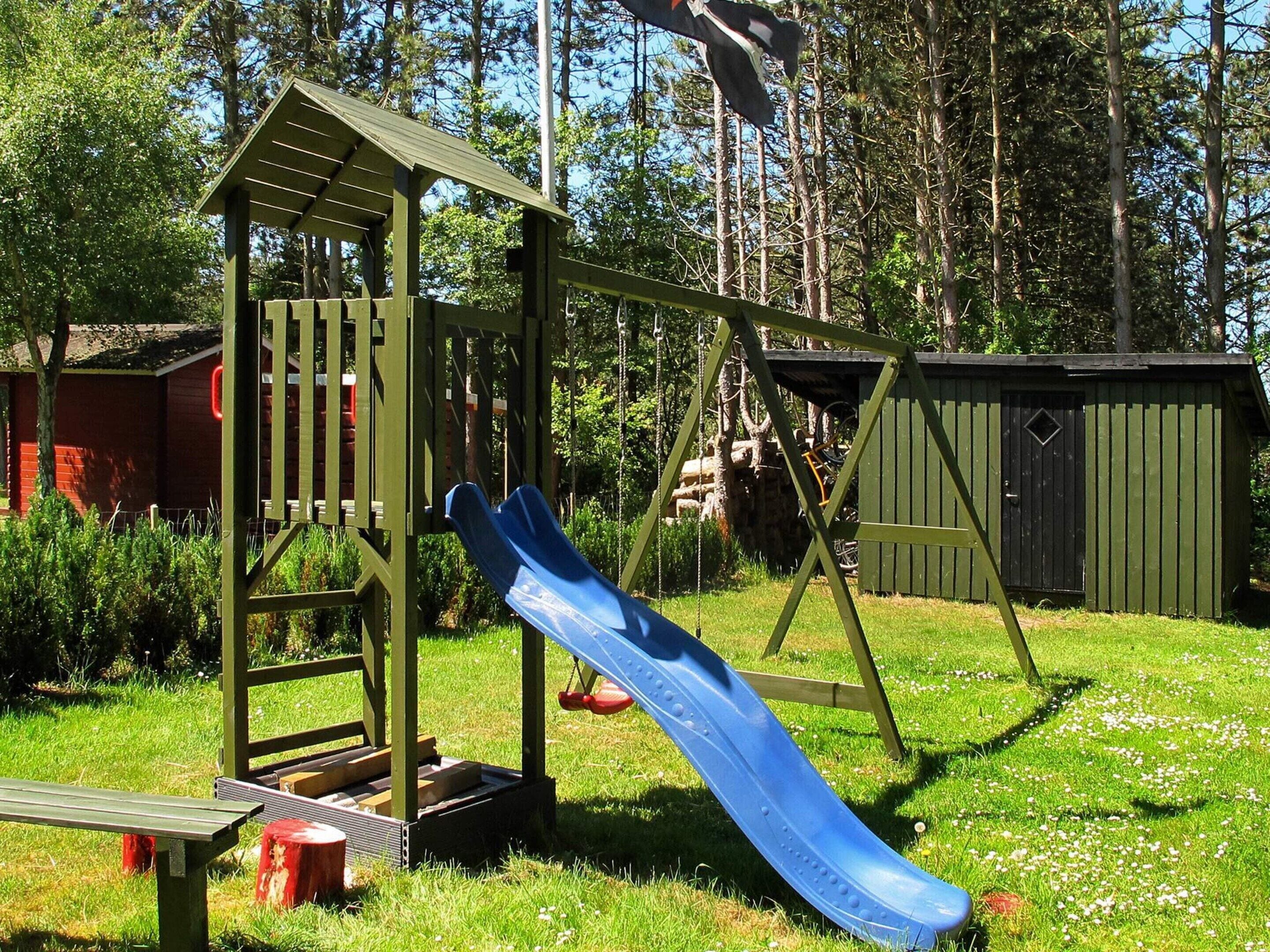 Ein Spielplatz mit einer Rutsche und einer Kletterkonstruktion.
