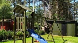A playground with a slide and a climbing structure. - 5 Star Holiday Home in Rodby (Rodby)