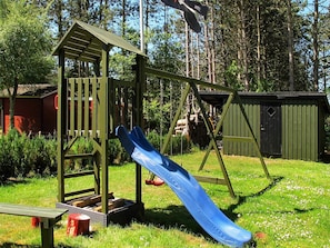 A playground with a slide and a climbing structure. - 5 Star Holiday Home in Rodby (Rodby)