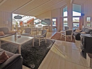 A spacious living area with a fireplace, seating arrangements, and a television. - Holiday Home in Otterndorf (Otterndorf)