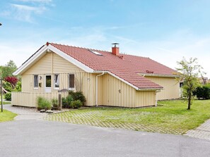 A single-story house with a red-tiled roof, a chimney, and a number '27' on the side. - Holiday Home in Otterndorf (Otterndorf)
