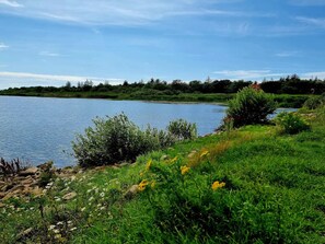 A natural landscape with a body of water, grassy areas, and trees. - Secluded Holiday Home in Henne near Beach (Henne)