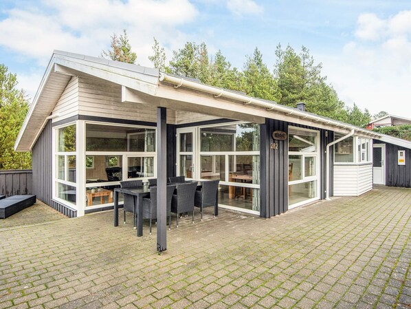 A modern house with a covered patio, large windows, and a number '282' sign.