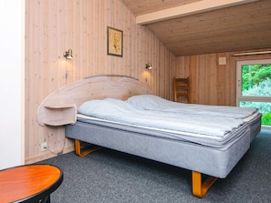 A single bed with a headboard, a bedside table, and a window with a view of greenery. - Secluded Holiday Home in Henne near Beach (Henne)