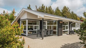 Ein modernes Gebäude mit einer überdachten Terrasse, großen Fenstern und einem Schild mit der Nummer 282.