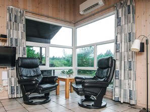 A room with two leather recliners, a small table, a TV, and large windows with curtains. - Secluded Holiday Home in Henne near Beach (Henne)