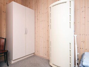 A room with a white wardrobe, a wooden chair, and a white radiator. - Secluded Holiday Home in Henne near Beach (Henne)