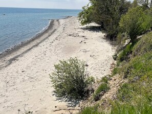 A sandy beach with a clear view of the ocean and some vegetation. - 5 Star Holiday Home in Idestrup (Idestrup)