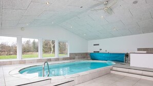 A large indoor swimming pool with a clear view of the outdoors through large windows. - 5 Star Holiday Home in Hals (Hals)