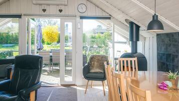 Un interior acogedor con comedor, chimenea y vistas al jardín.