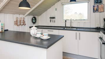 Una cocina con una isla central, un ventanal y un lavabo.