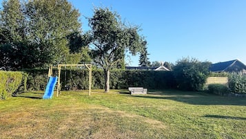 A backyard with a swing set and a slide.