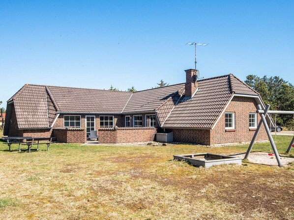 A two-story brick house with a sloped roof, a chimney, and a satellite dish. - 10 Person Holiday Home in Blavand (Blavand)