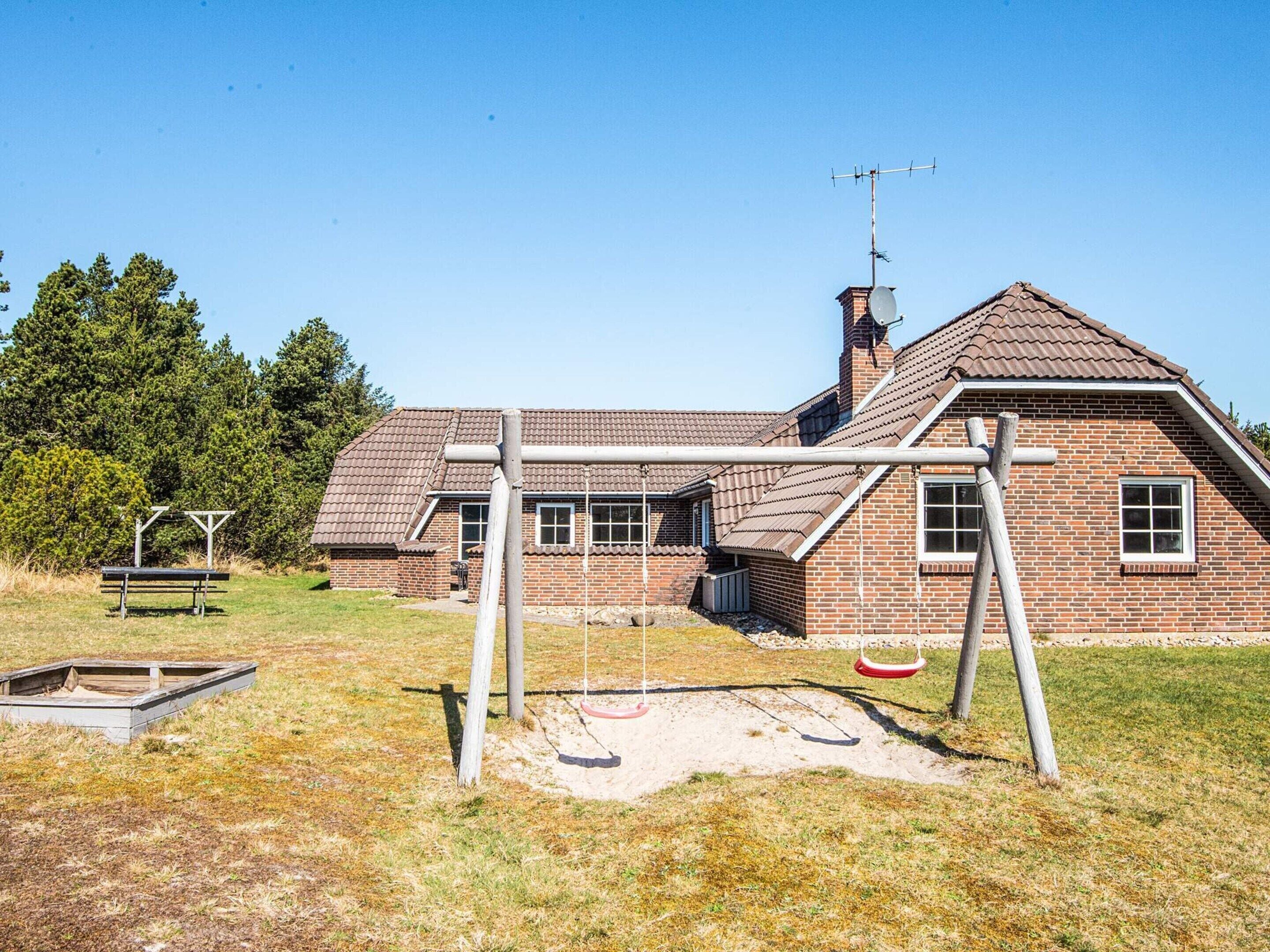 A brick building with a pitched roof, a chimney, and a satellite dish.