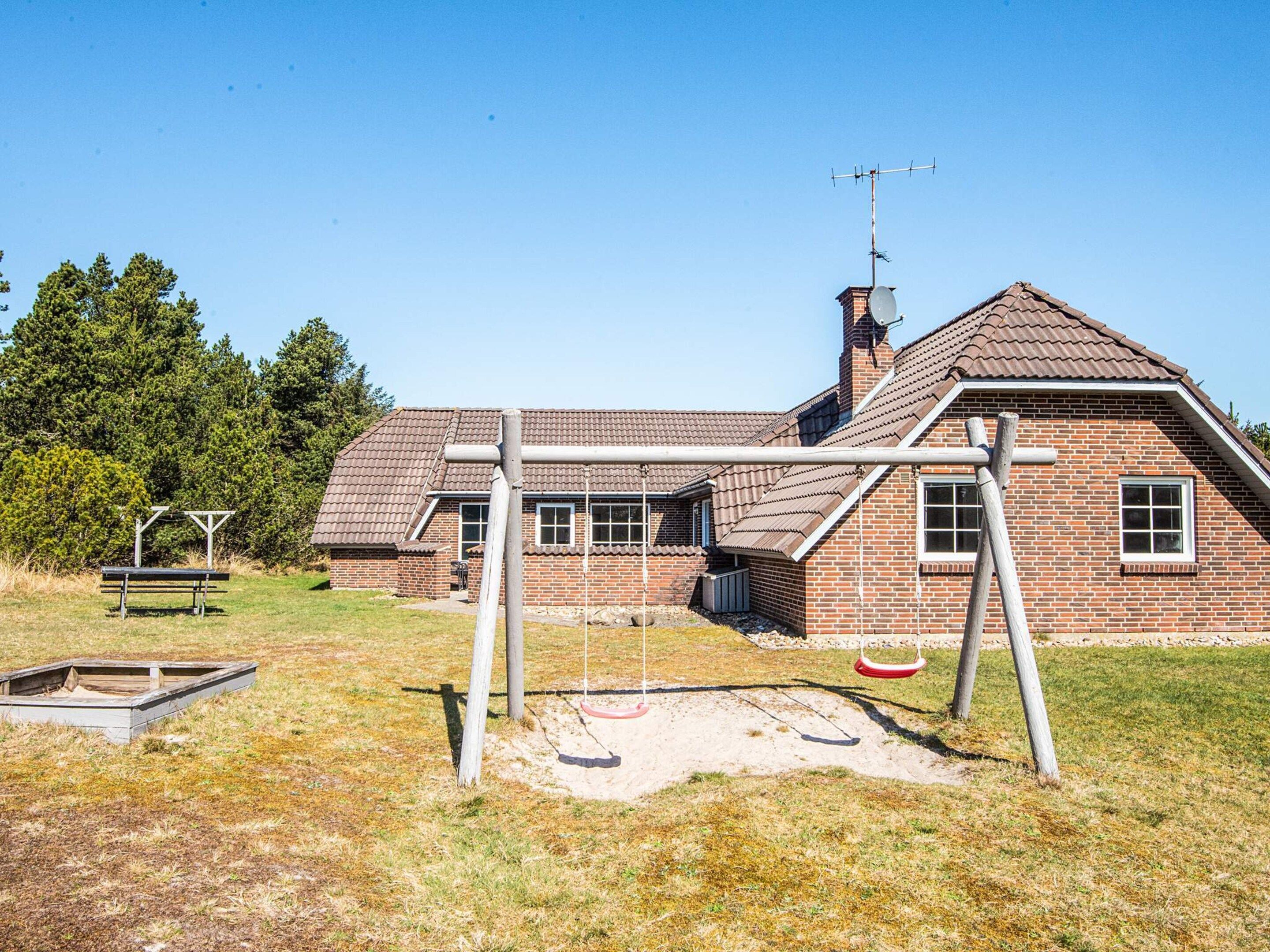 A brick building with a pitched roof, a chimney, and a satellite dish.