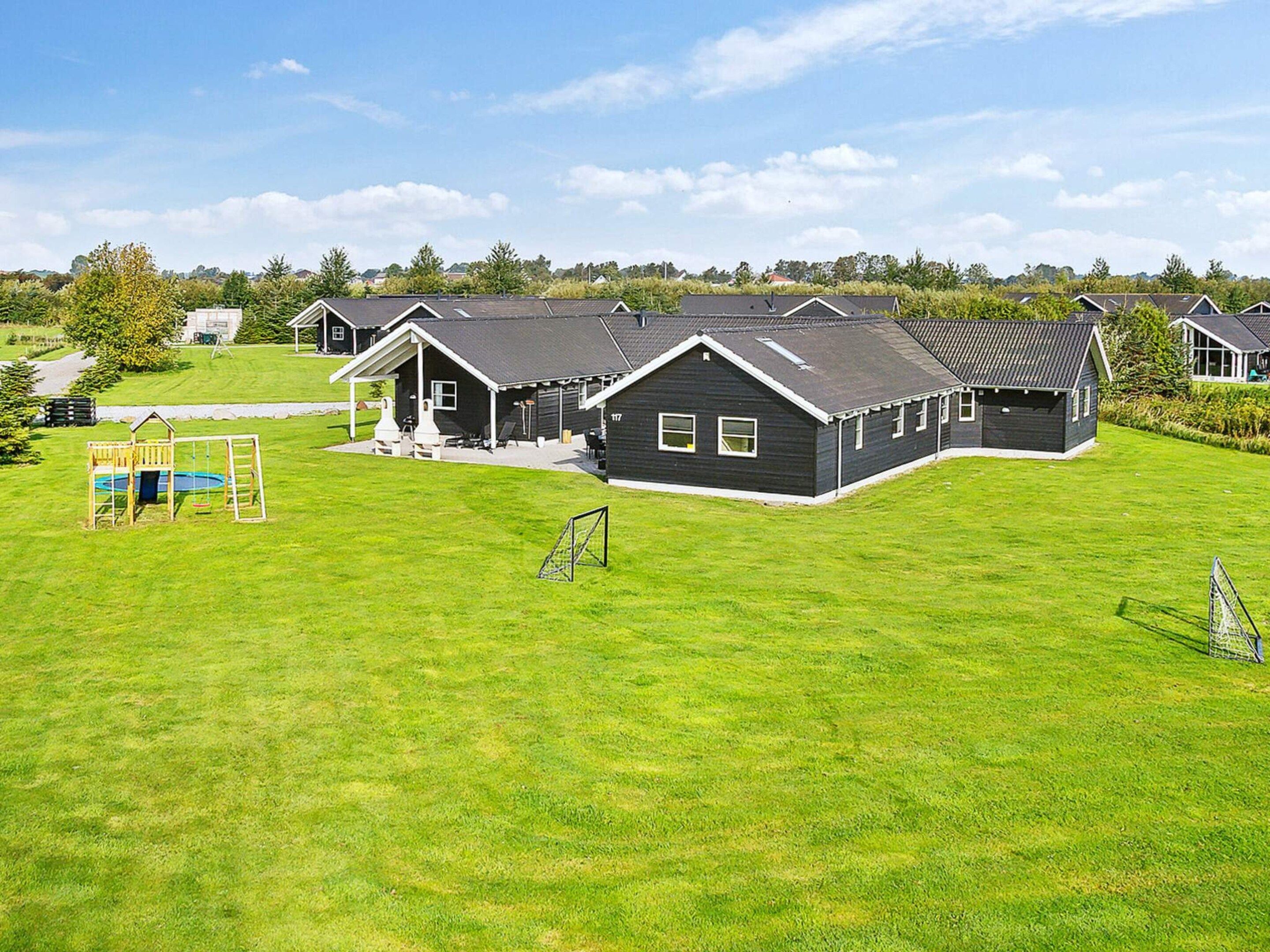 A residential area with multiple houses, a playground, and a well-maintained lawn.