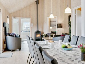 A modern living room with a fireplace, seating area, and dining space.