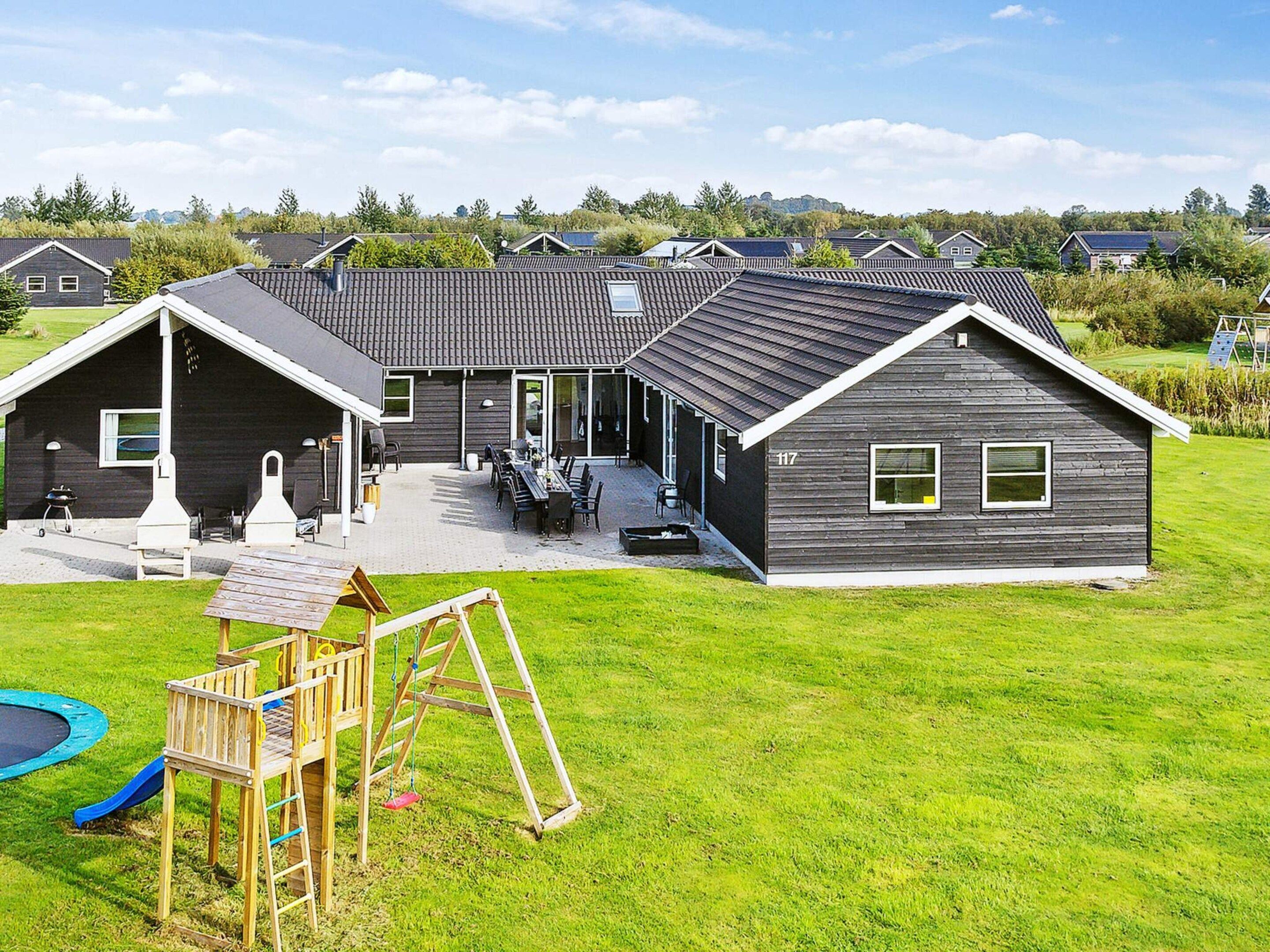 A residential property with a patio, outdoor seating, and a play area.