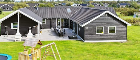 A residential property with a patio, outdoor seating, and a play area.