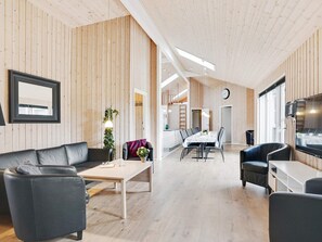 A modern interior with a dining area, sofas, and a TV. - 5 Star Holiday Home in Idestrup (Idestrup)
