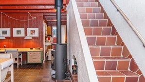 Een knus interieur met een open haard, houten meubels en een betegelde vloer.