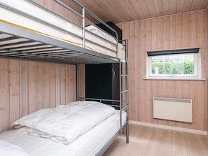 A bunk bed room with wooden walls, a window with a view, and a radiator. - 5 Star Holiday Home in Ansager (Ansager)