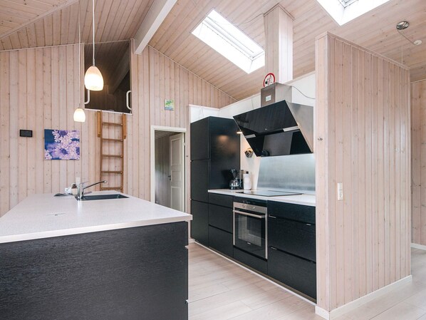 Una cocina moderna con paneles de madera, una isla central y un tragaluz.