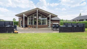 Un bâtiment moderne doté de grandes fenêtres et d’un patio couvert.
