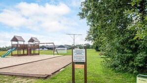 A playground with a slide, swings, and a sandpit. - 5 Star Holiday Home in Ansager (Ansager)