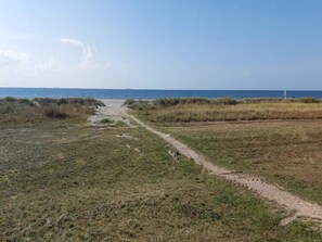A coastal path leading to the sea with grassy areas and a clear sky. - 5 Person Holiday Home in Rodby-by Traum (Rodby)
