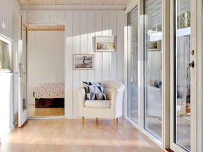 A room with a bed, a chair, and a large window.