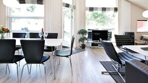 Un espace de restauration moderne doté de hauts plafonds, de grandes fenêtres et d’un agencement combinant des espaces repas et des espaces de travail.