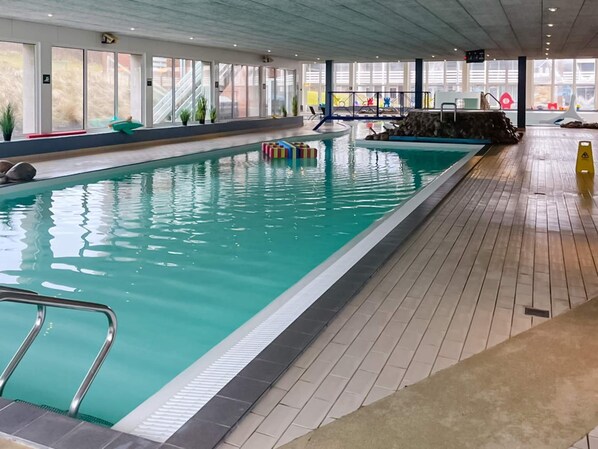 Swimmers can enjoy a refreshing dip in the pool surrounded by a tiled floor.