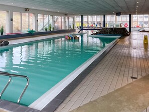 An indoor swimming pool with clear water, tiled floor, and a lifeguard station. - 5 Star Holiday Home in Ringkobing (Ringkobing)