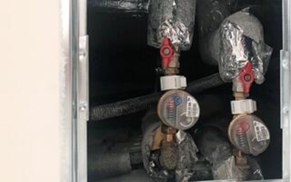 A close-up of a mechanical setup with pipes and valves, likely part of a building's infrastructure.