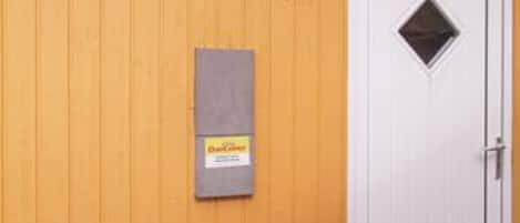 A wooden wall with a door and a mailbox.