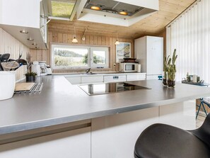 A modern kitchen with a central island, stainless steel appliances, and a view of the outdoors. - 4 Star Holiday Home in Hjorring (Hjørring)