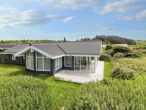 A modern house with a large deck, surrounded by lush greenery. - 4 Star Holiday Home in Hjorring (Hjørring)